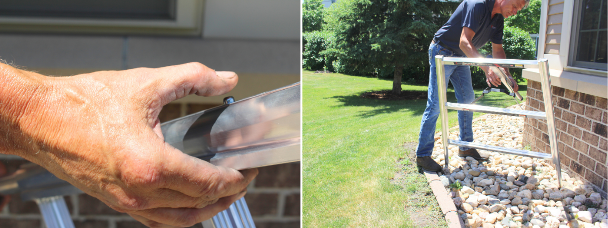 Close-up view of a person adjusting the height of an aluminum ladder leg using the TwistLok™ mechanism. The image shows the hand gripping the black locking knob on the ladder’s leg, demonstrating independent adjustment for uneven surfaces. The ladder is positioned outdoors on grass near a brick wall.
